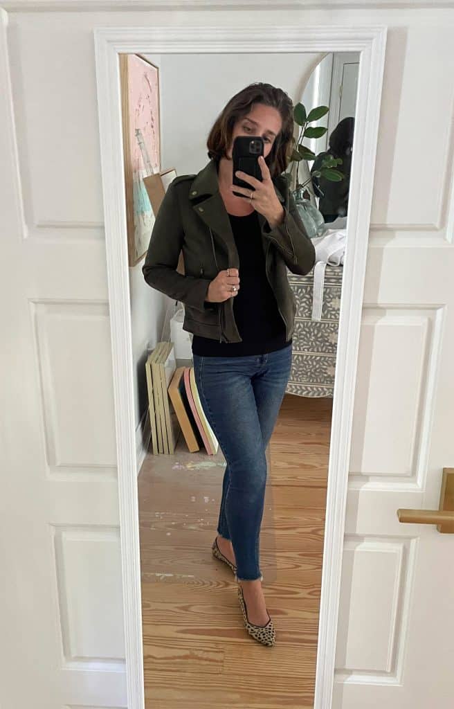 Sherry selfie in mirror at home with black tank top with green jacket with leopard print flats
