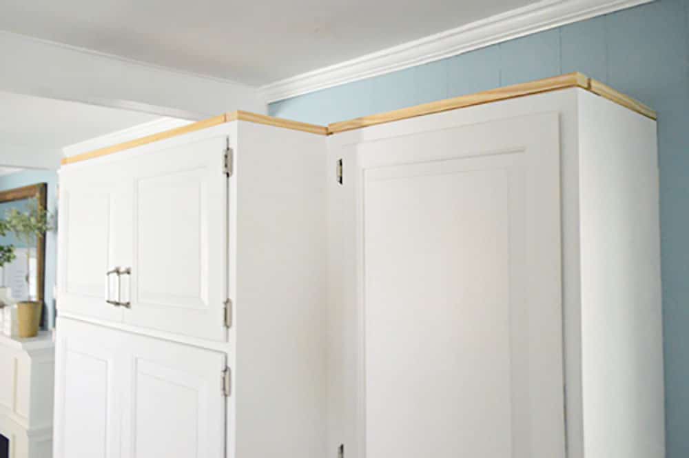 Scrap wood nailed along perimeter of upper cabinet in kitchen
