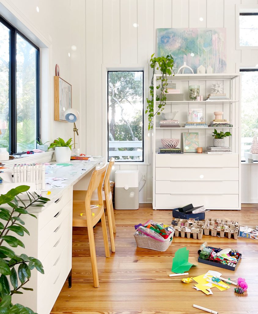 Bright Family Room Craft Space With Desk And Floor Covered With Craft And Art Supplies