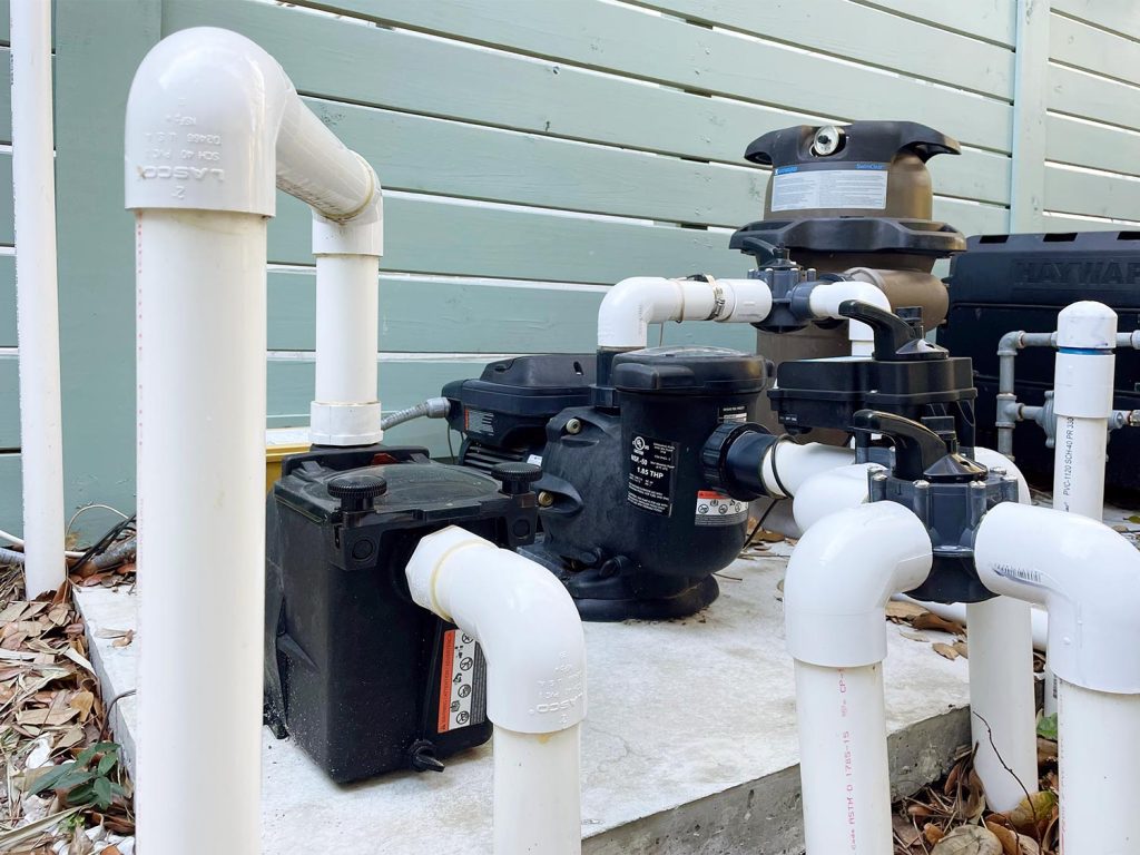 Pool equipment with exposed white PVC pipes