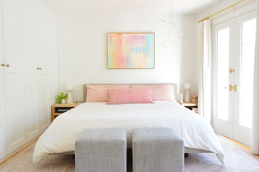 King Size Bed With White Bedding In Modern Bedroom With Striped Ottomans