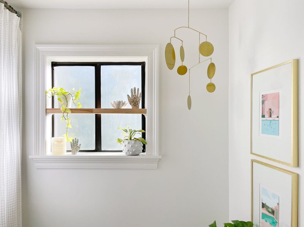 Modern White Bathroom With Floating Wood Shelf And Brass Mobile