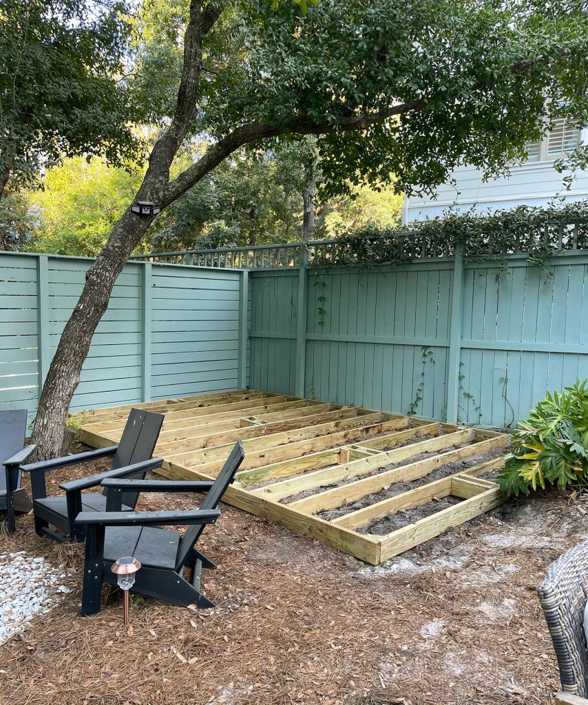 Deck Platform Under Construction In Backyard With Green Fence