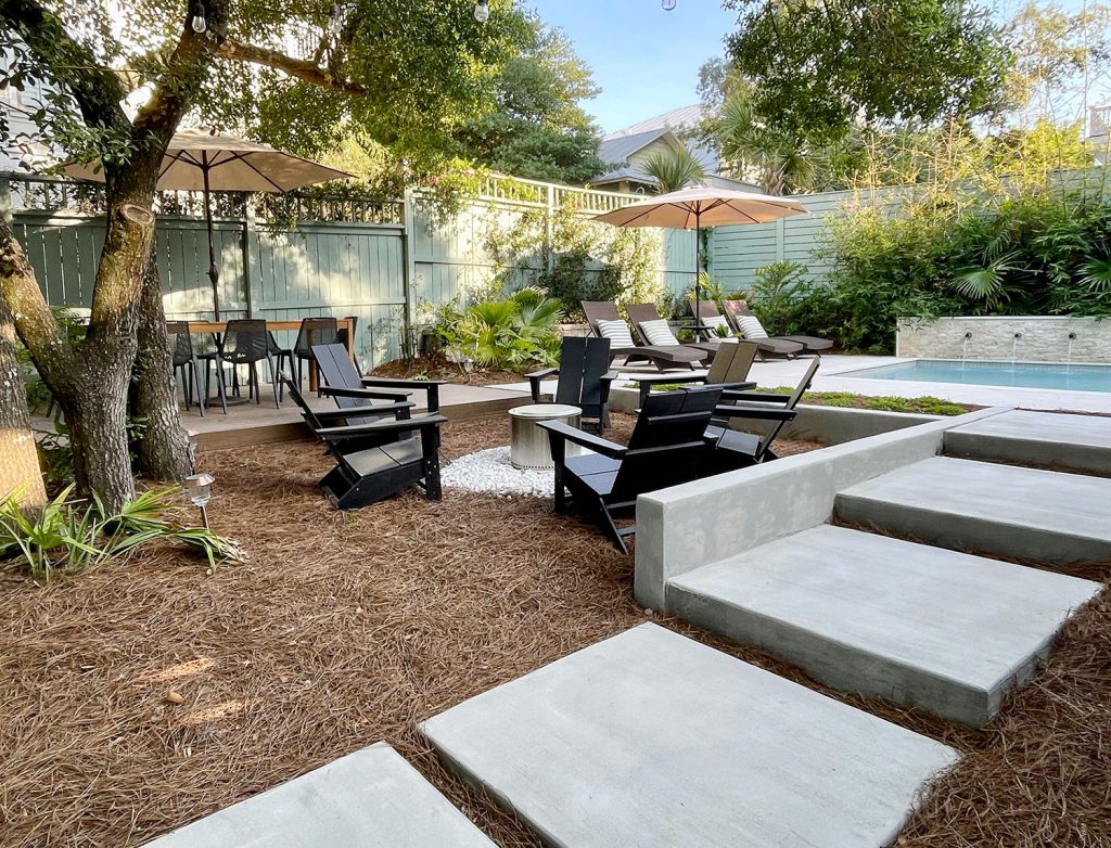 Concrete Steps Leading Up To Pool In Backyard With Firepit