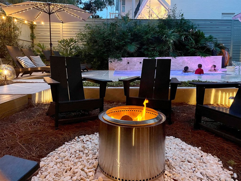 Solo Stove Firepit With Kids Playing In Pool In Backyard