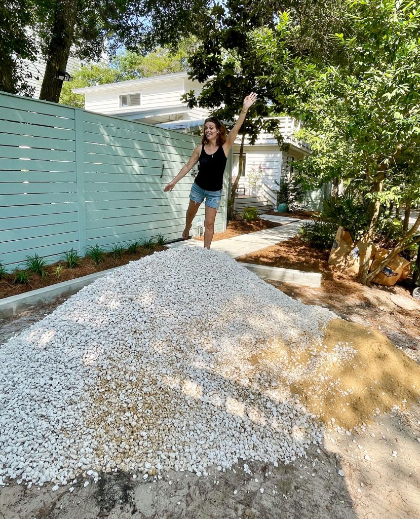 Sherry standing on top of freshly delivered pile of bahama rock gravel for driveway