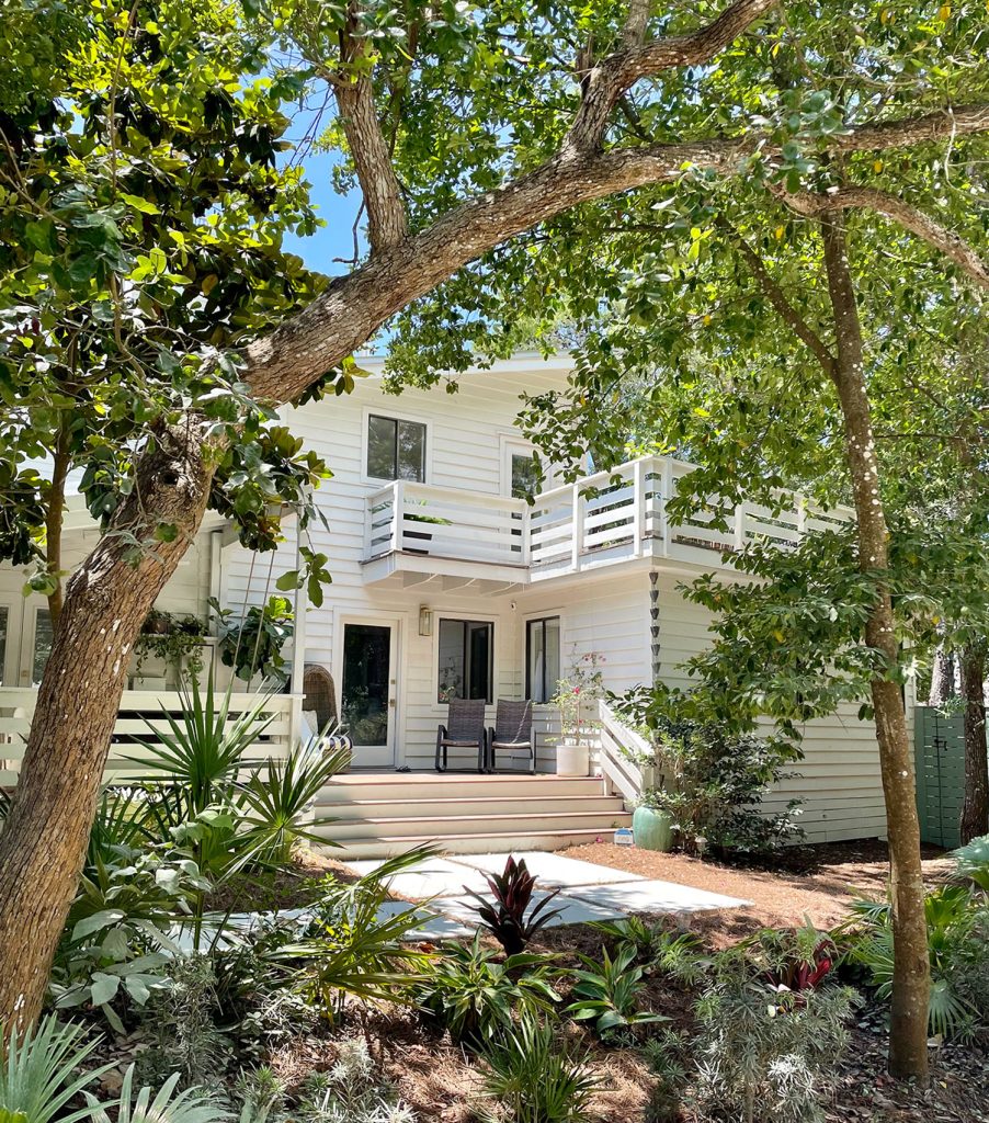 Front Of White Modern House With Lots of Greenery Angle