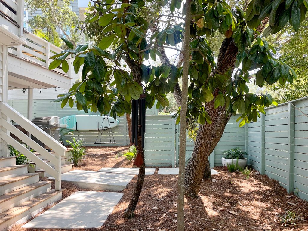 Side Yard With Trees And Steps And Green Fence With Poured Concrete Pavers