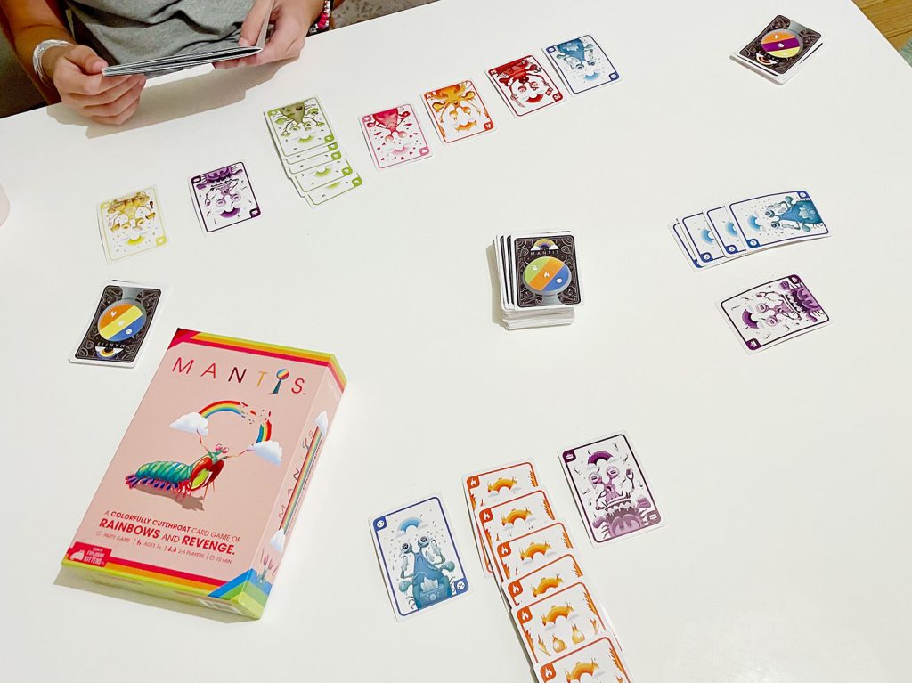 Mantis Colorful Card Game Being Played On Table