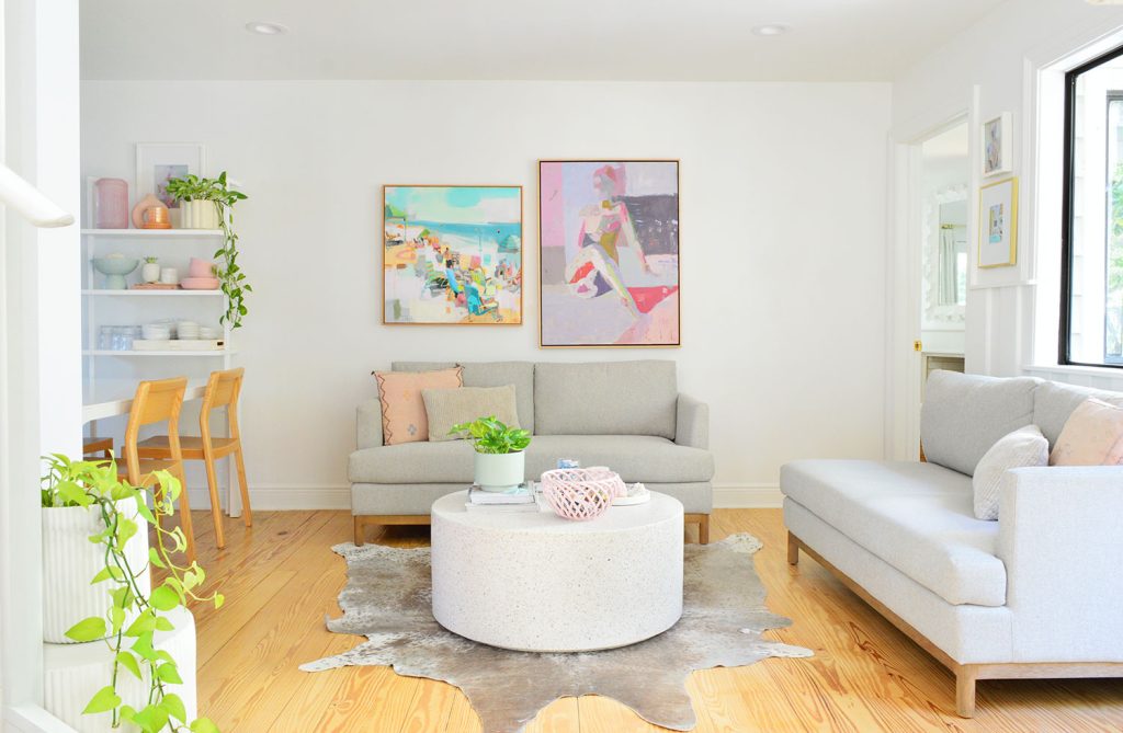 White Kitchen Sitting Area With Two Loveseats And Colorful Artwork