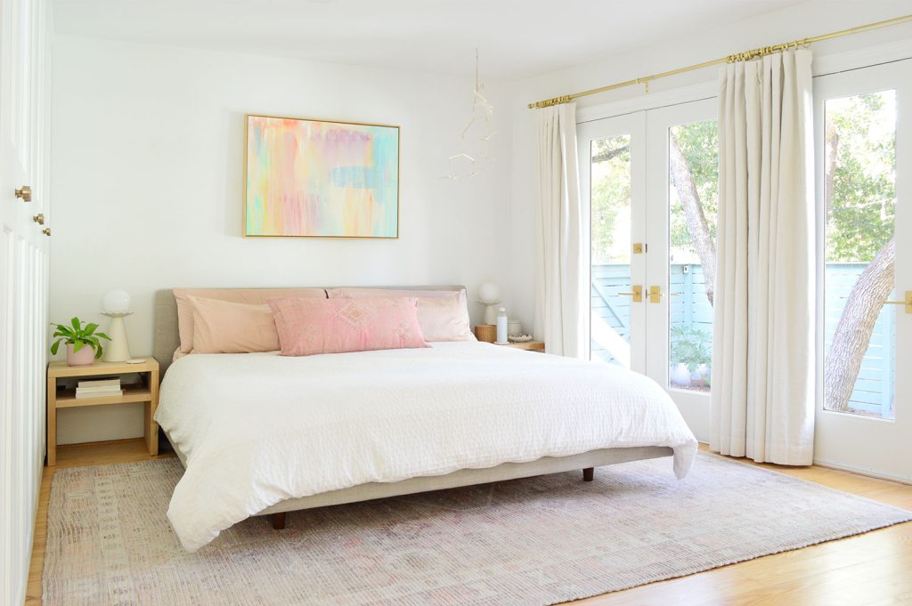 Bright Beachy Bedroom With Colorful Painting And French Door Overlooking Yard