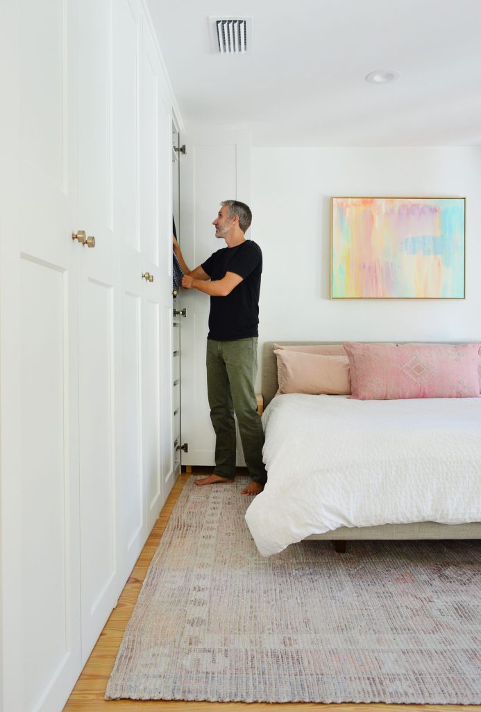 Man Standing At Ikea Pax Closet Wall With Colorful Pink Painting