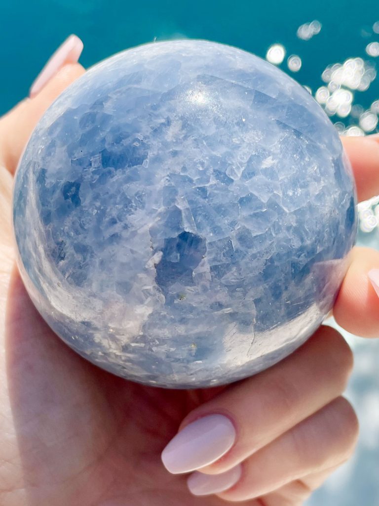 Blue Calcite Crystal Sphere Over Water