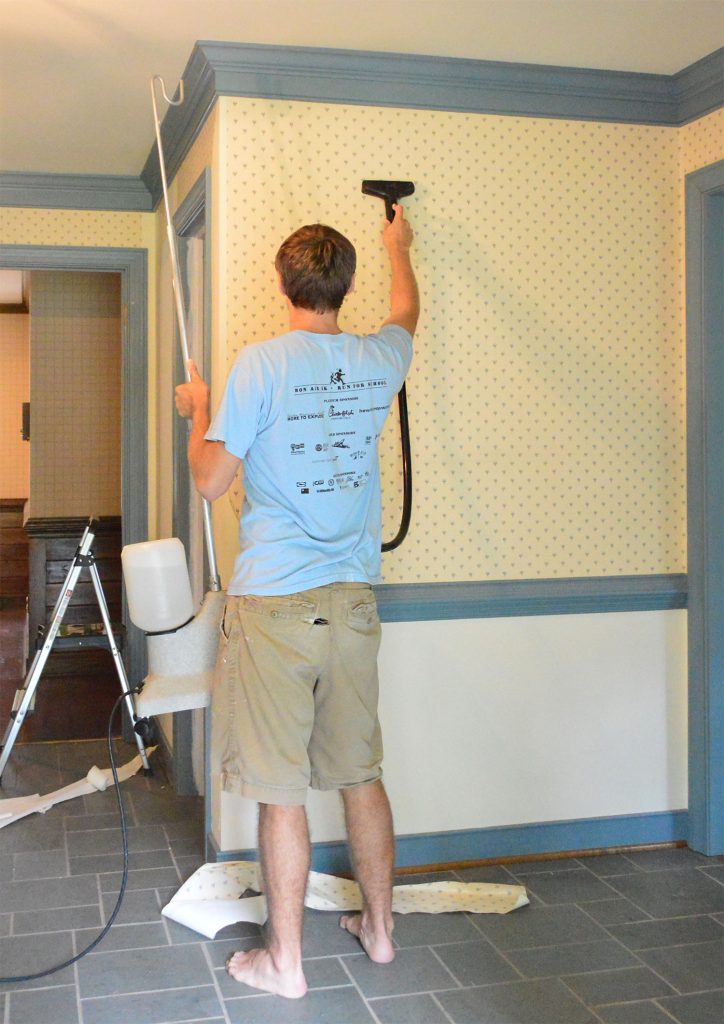 John Using Steamer On Wallpaper In Foyer