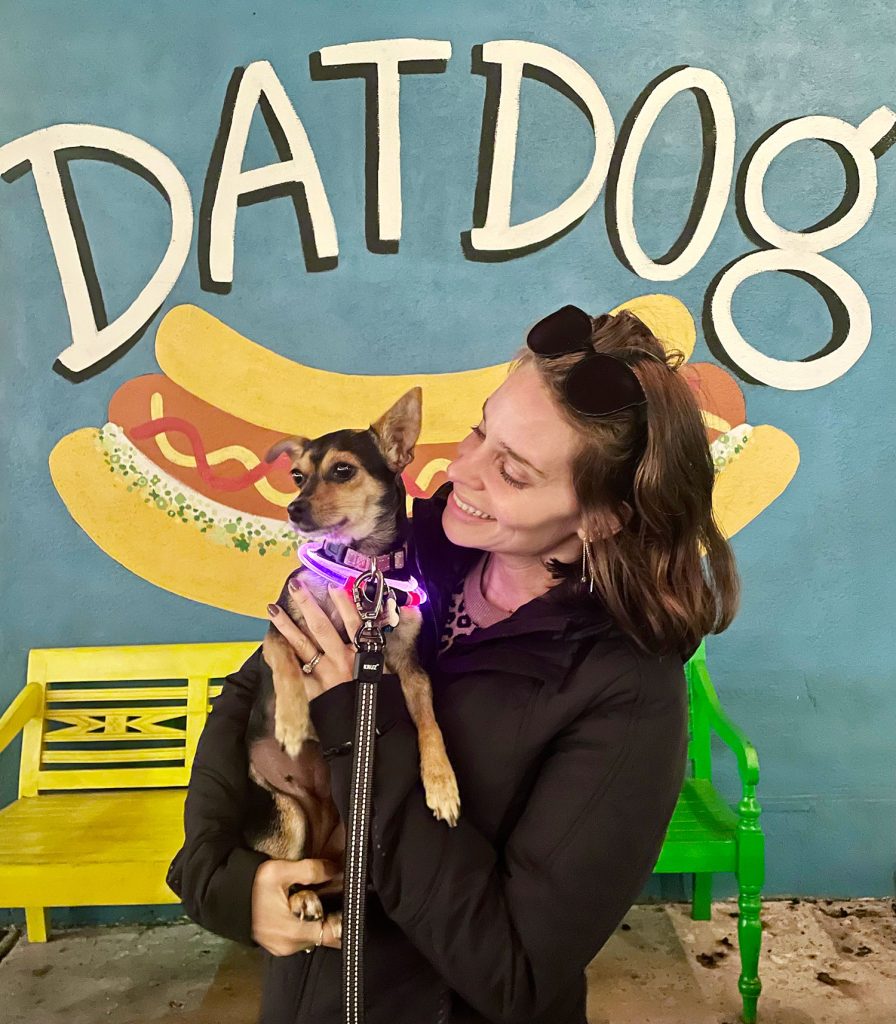 Sherry Holding Chihuahua In Front Of Dat Dog Mural New Orleans