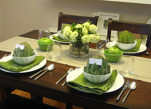 Table setting with green napkins and artichokes as placecard holders