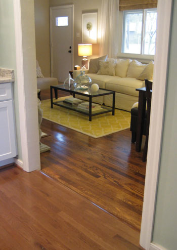 clean hardwood floor showing transition between original oak hardwood and engineered hardwood installed to closely match