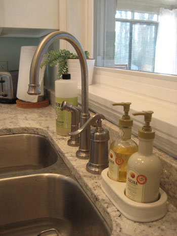 Soap dispenser next to kitchen sink faucet