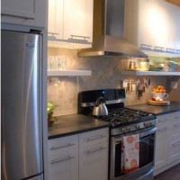 A White Kitchen With Black Counters And Open Shelves