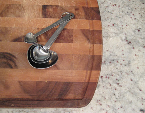 Heart shaped Measuring Spoons On Wood Cutting Board