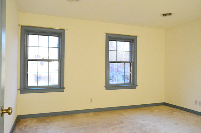 Bedroom before with cream walls and blue trim