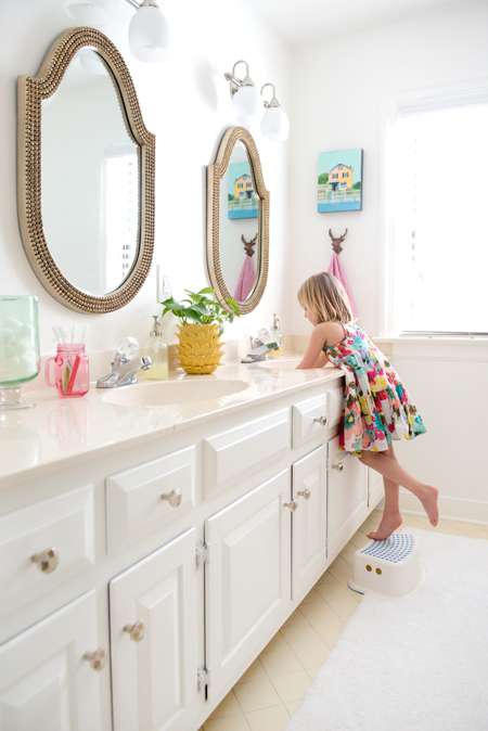 Mid Point Of Hall Bathroom With White Vanity And Walls And Decorative Beaded Mirrors