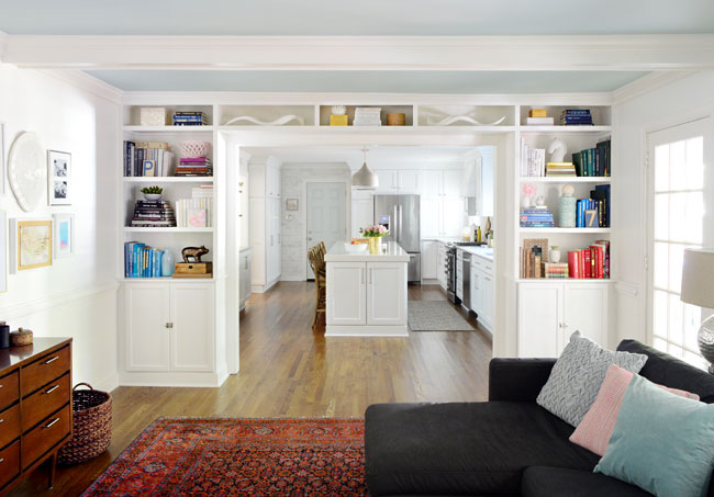 white built-in bookshelves between living room and kitchen