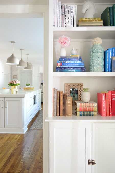 white built-in bookshelves with kitchen in background