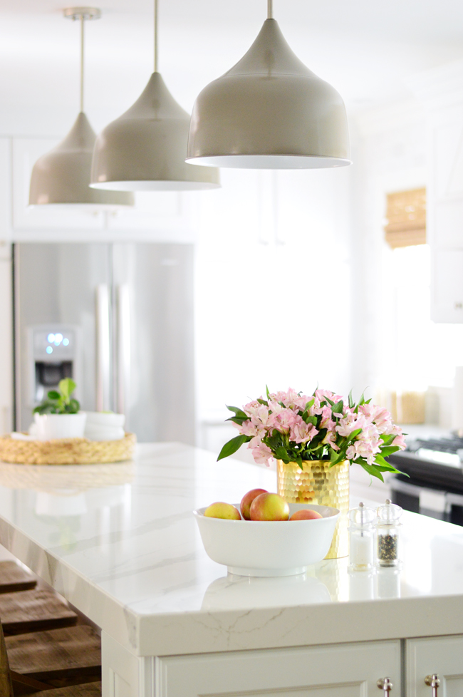 white kitchen with large gray pendant lights shades of light