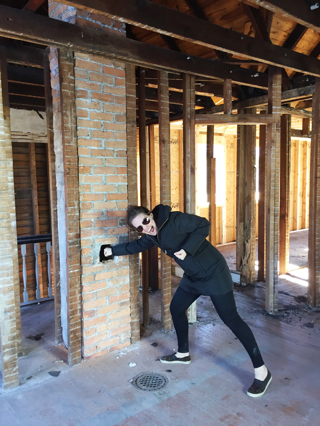 Demo Stage Photo With Sherry Punching At Hole In Exposed Brick Chimney