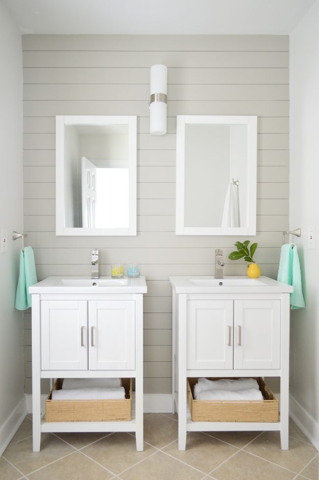 pair of vanities in bathroom staged to sell with gray shiplap wall