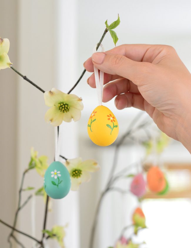 placing decorative painted egg on Easter Tree