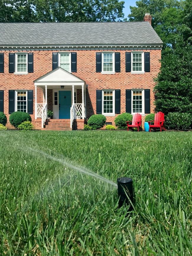 irrigation system sprinkler head spraying lawn close-up