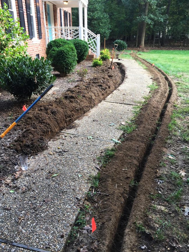 install irrigation system trenches along pathway 