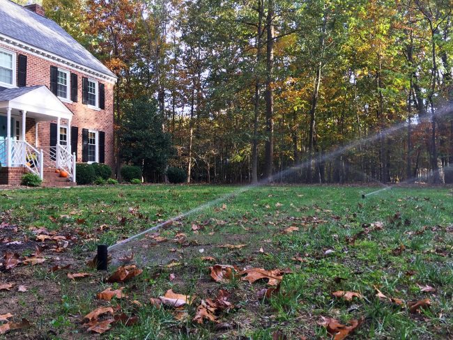 instalação de sistema de irrigação regeneração de grama no jardim da frente aspersores ligados