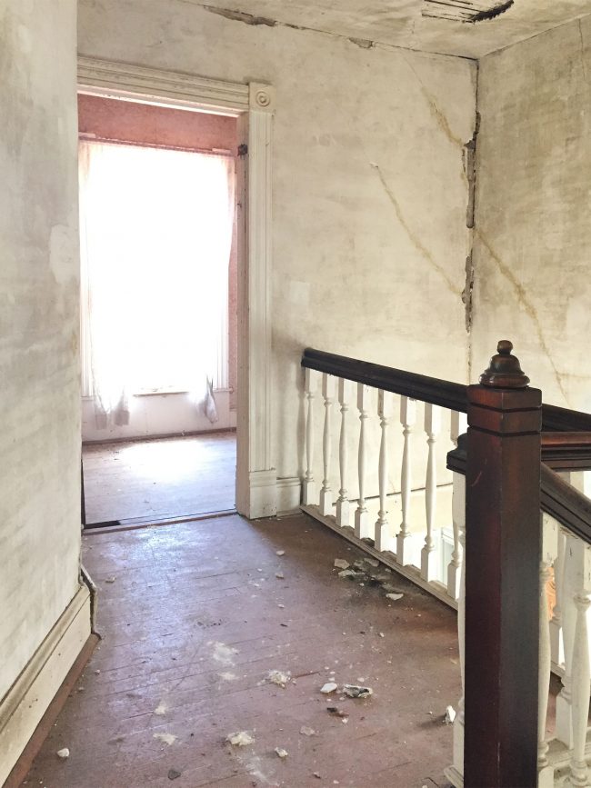 beach house before upstairs landing crumbling drywall painted floor