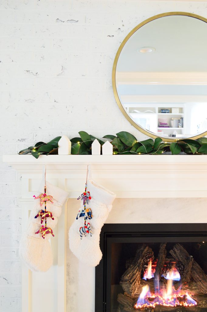 Detail of white traditional fireplace surround with stockings and garland