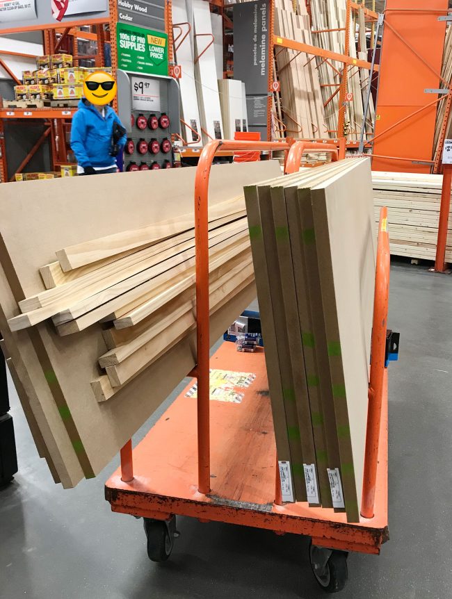 cart full of MDF and wood pieces for pantry shelf project