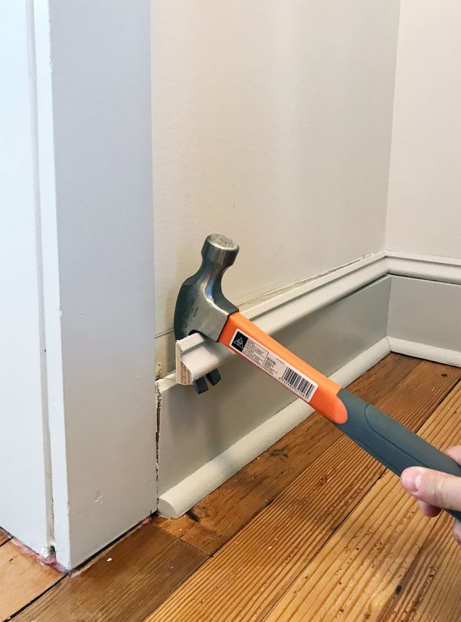 hammer prying off baseboard molding in pantry