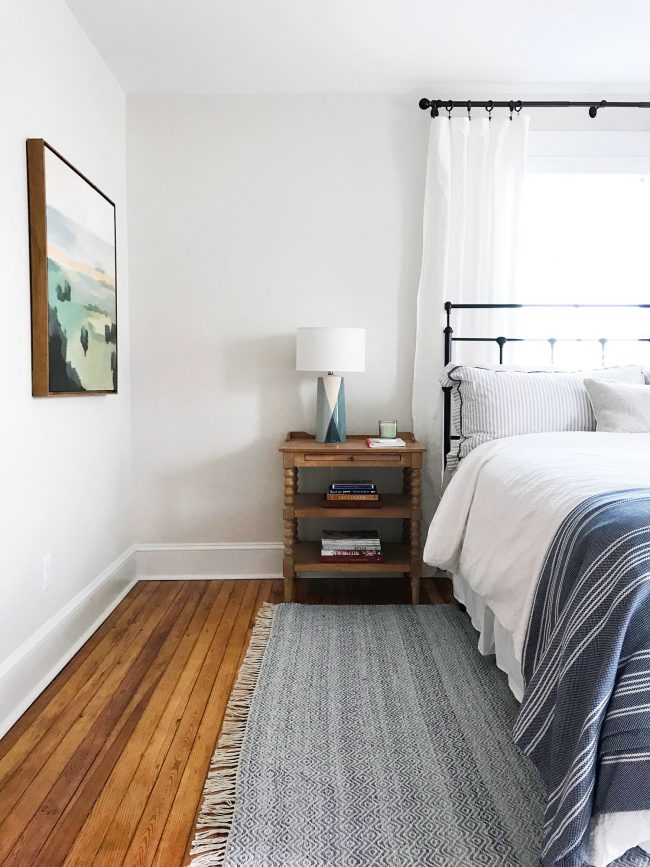 metal headboard in beachy blue bedroom with pine floors