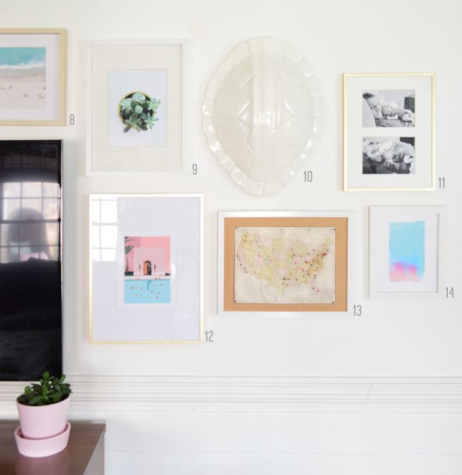 grid of white and gold frames on white gallery wall