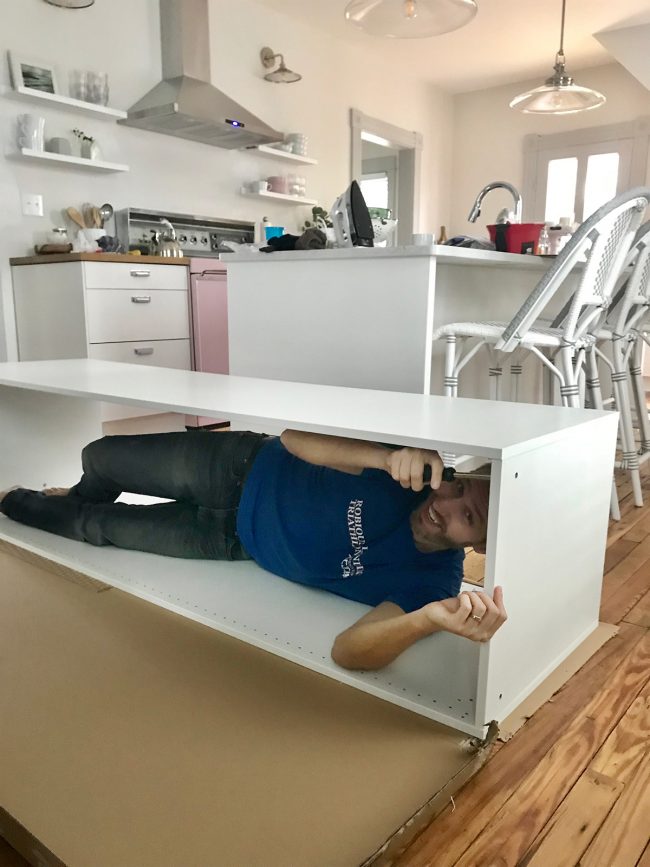 john laying in ikea cabinet during assembly