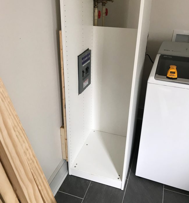 ikea pax wardrobe pressed against wall with cutouts for breaker box