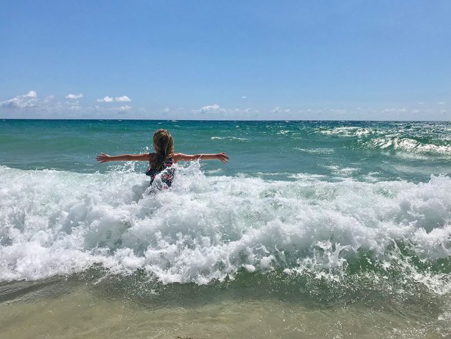 little girl playing in waves during Spring Break in Lauderdale By The Sea Florida