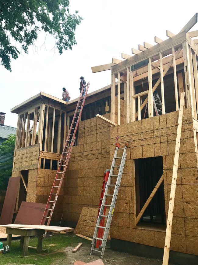 Duplex Construction Back Of House With Men On Roof