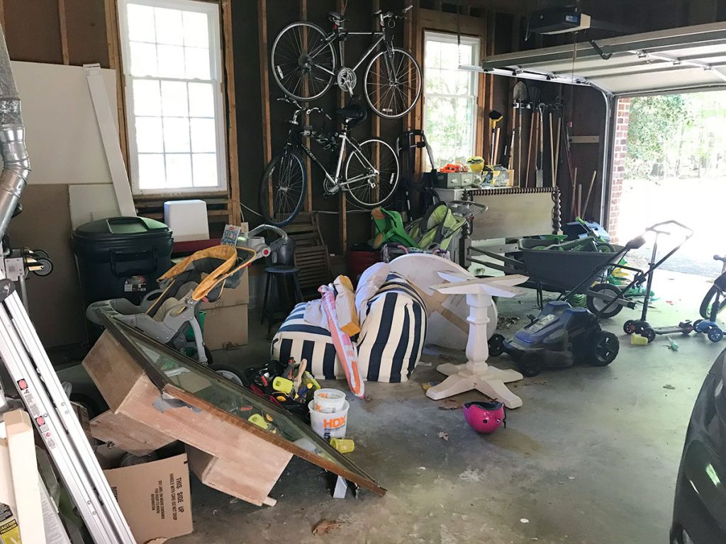 Garage Filled With Junk Like Yard Equipment Boxes And Extra Furniture