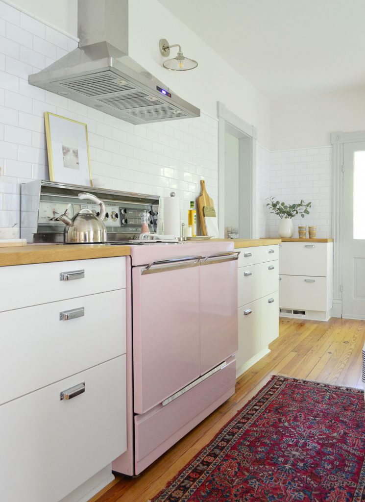 beach house kitchen with pink stove and white subway backsplash