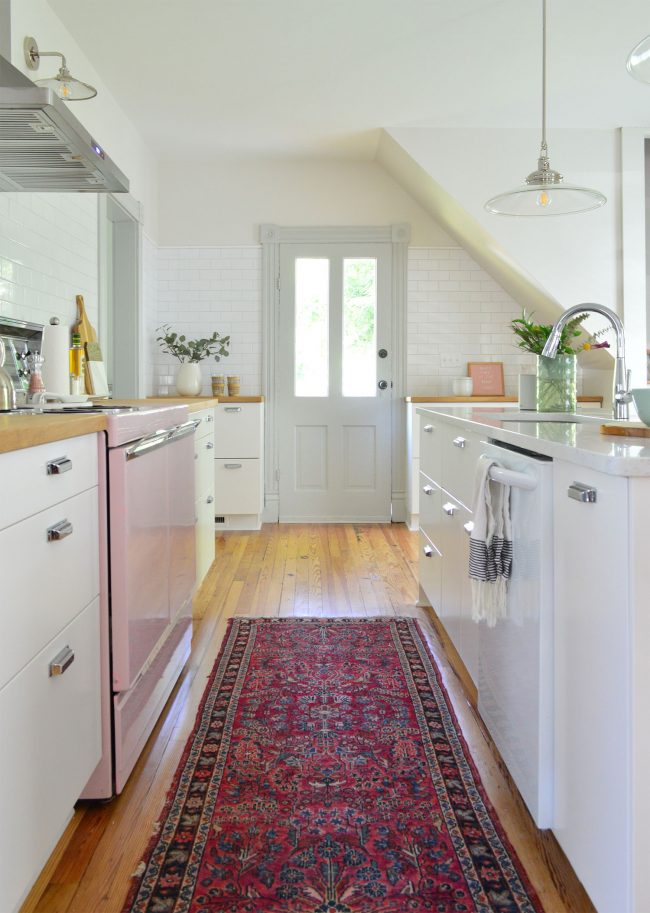 After Photo Of Beach House Kitchen Towards Back Door With Ikea Cabinets Subway Tile Backsplash and Intricate Moldings