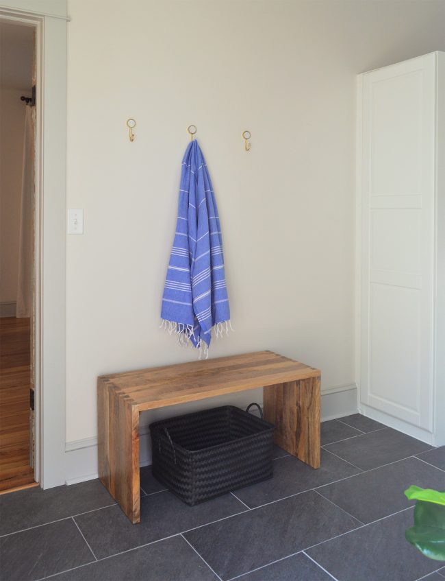 before photo with three gold hooks on wall in mudroom