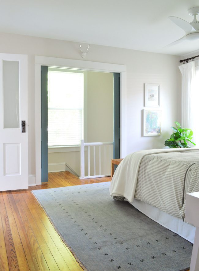 After Photo of Beach House Back Bedroom With Blue Pocket Doors Over Stair Railing